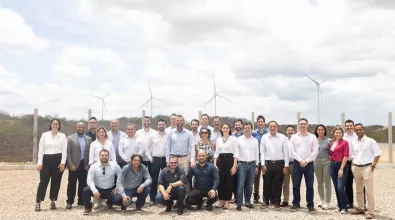 A photo of a team of EDP workers from Brazil in front of some wind turbines